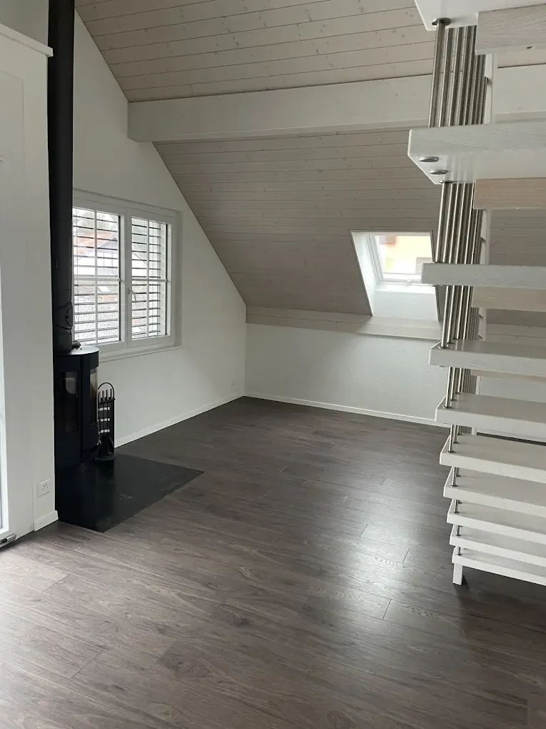 Combles rénovés avec parquet et murs blancs